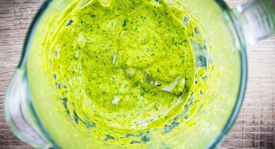 Salsa verde cremosa de chile poblano recién licuada, lista para mezclar con la pasta.