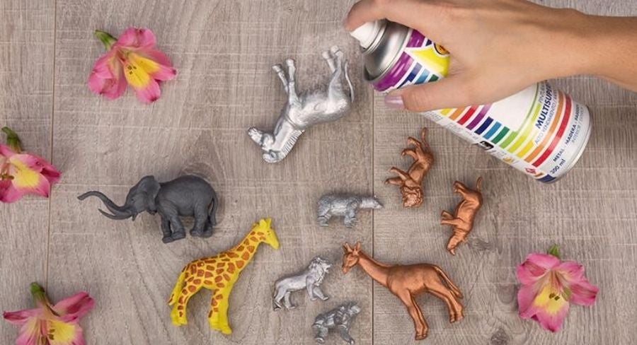Para comenzar tus manualidades de reciclaje toma cada uno de los animalitos y aplica la pintura en aerosol. Cubre la superficie donde vas a pintar con periódico, así evitarás que se manche y preservarás la limpieza de hogar.