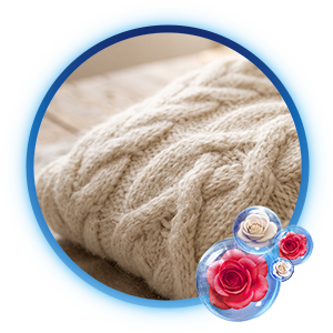 Primer plano de un suéter de lana beige tejido, suave y aromático, con burbujas de rosas Suavitel, ideal tras el lavado cuidadoso.