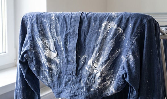 Camisa azul colgada con residuos blancos de detergente en polvo acumulados tras el lavado.