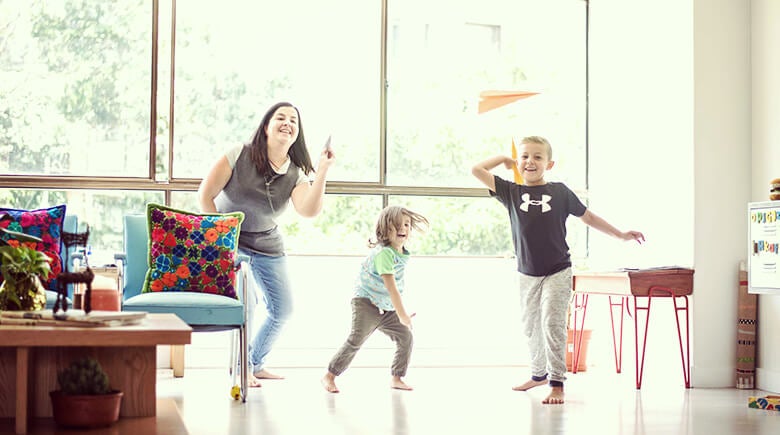 Madre jugando con sus dos hijos con aviones de papel