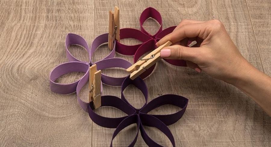Juntando con pinzas varias flores formadas con tubos de papel higiénico
