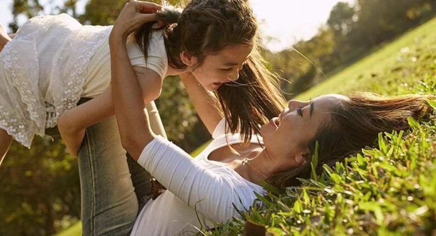 mamá e hija jugando en un parque