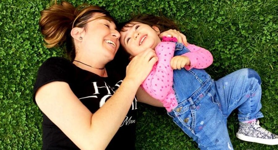 Madre e hija felices jugando en el césped