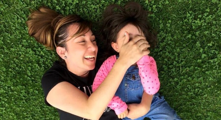 Madre e hija felices jugando en el césped