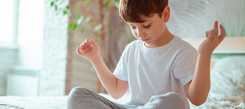 niño en posición del loto durante una sesión de meditación