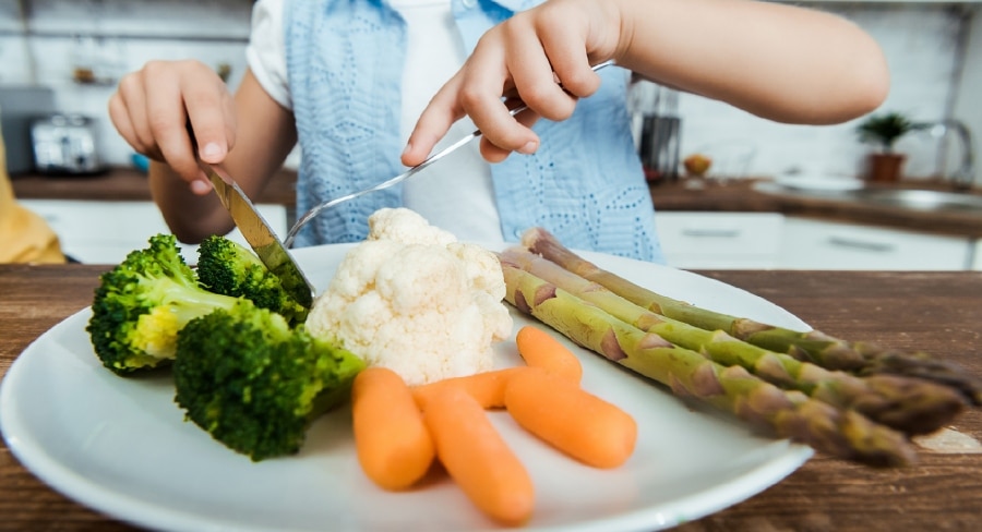 niño comiendo verduras saludables