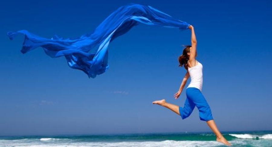 mujer con un velo azul en la playa