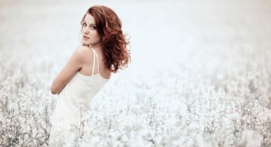 Mujer con vestido blanco y fondo de flores blancas