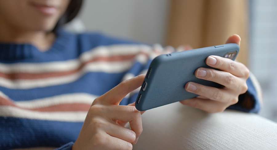 mujer utilizando su celular en casa