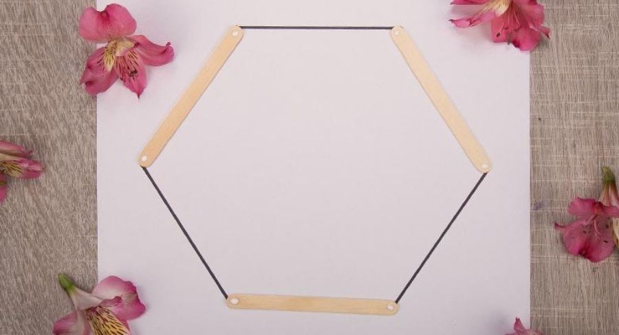 Hoja de papel formando un hexagono con palitos de paleta.