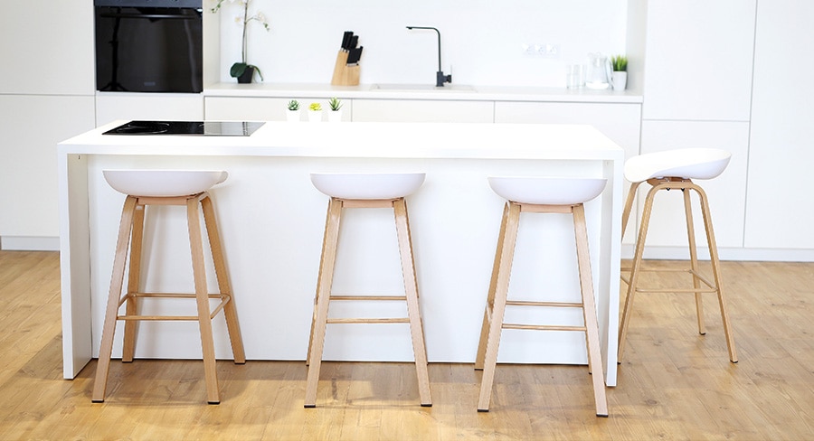 cocina blanca con piso de madera y desayunador