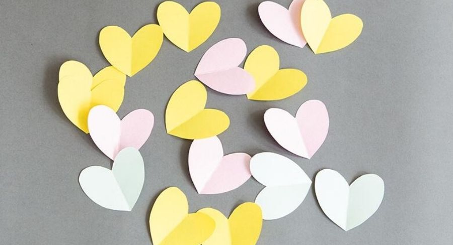 Corazones de papel cortados y doblados por la mitad