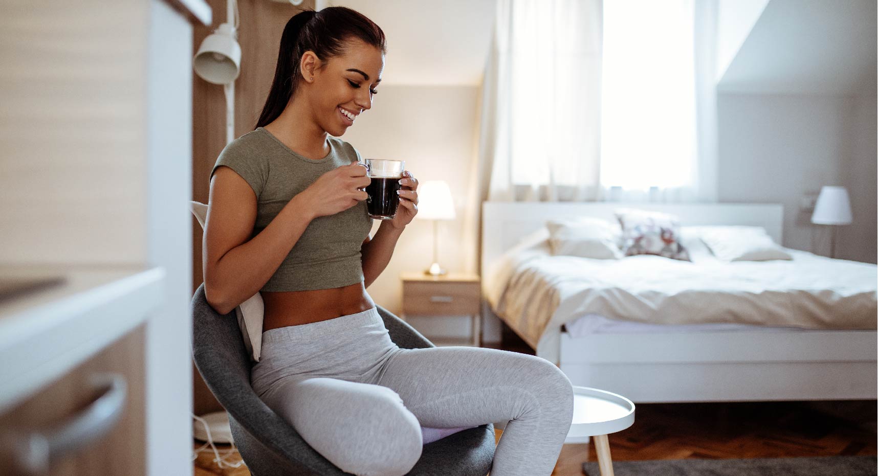 mujer tomando una taza de café en su habitación