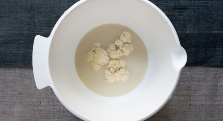 Preparación de nuggets de coliflor: Toma varios floretes y sumérgelos en la leche de almendras.