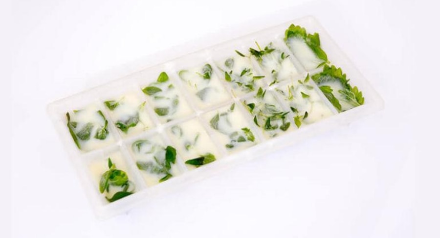 Mezcla de hierbas en moldes para cubos de hielo