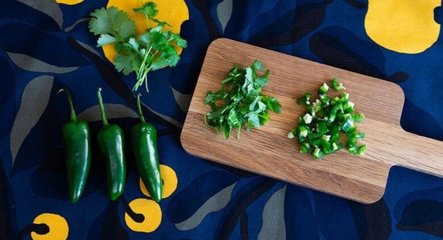 Chile y cilantro picado en una tabla de madera