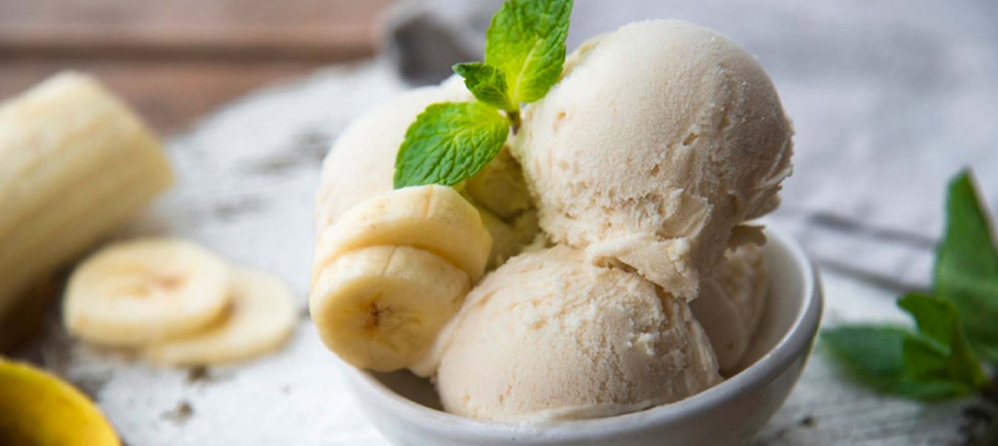 bola de helado de plátano y plátano sobre mesa de madera