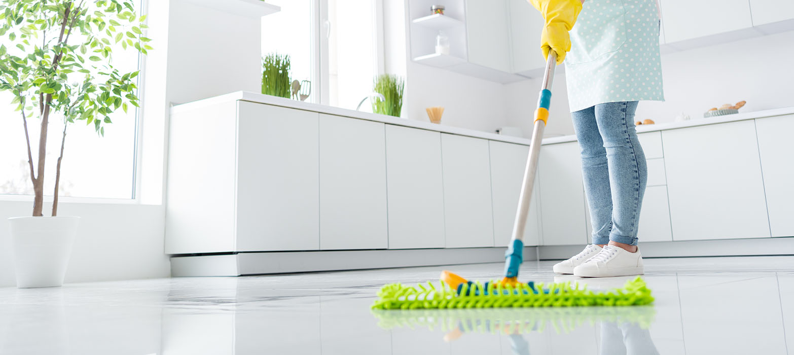 mujer con detergente y trapo en mano lista para comenzar la limpieza del hogar