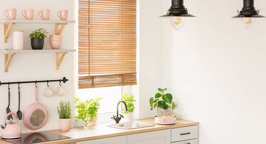 cocina con persianas, lámparas, accesorios rosados y plantas