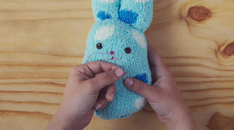 Muñecos con calcetines: Cose los ojos y la nariz del conejo