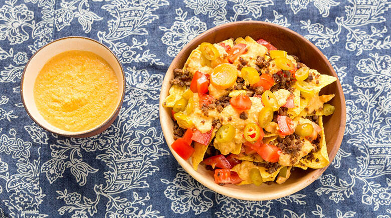 Plato de nachos con un plato de queso derretido